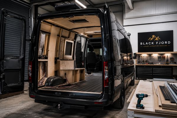 Interior view of a van being converted in a workshop.