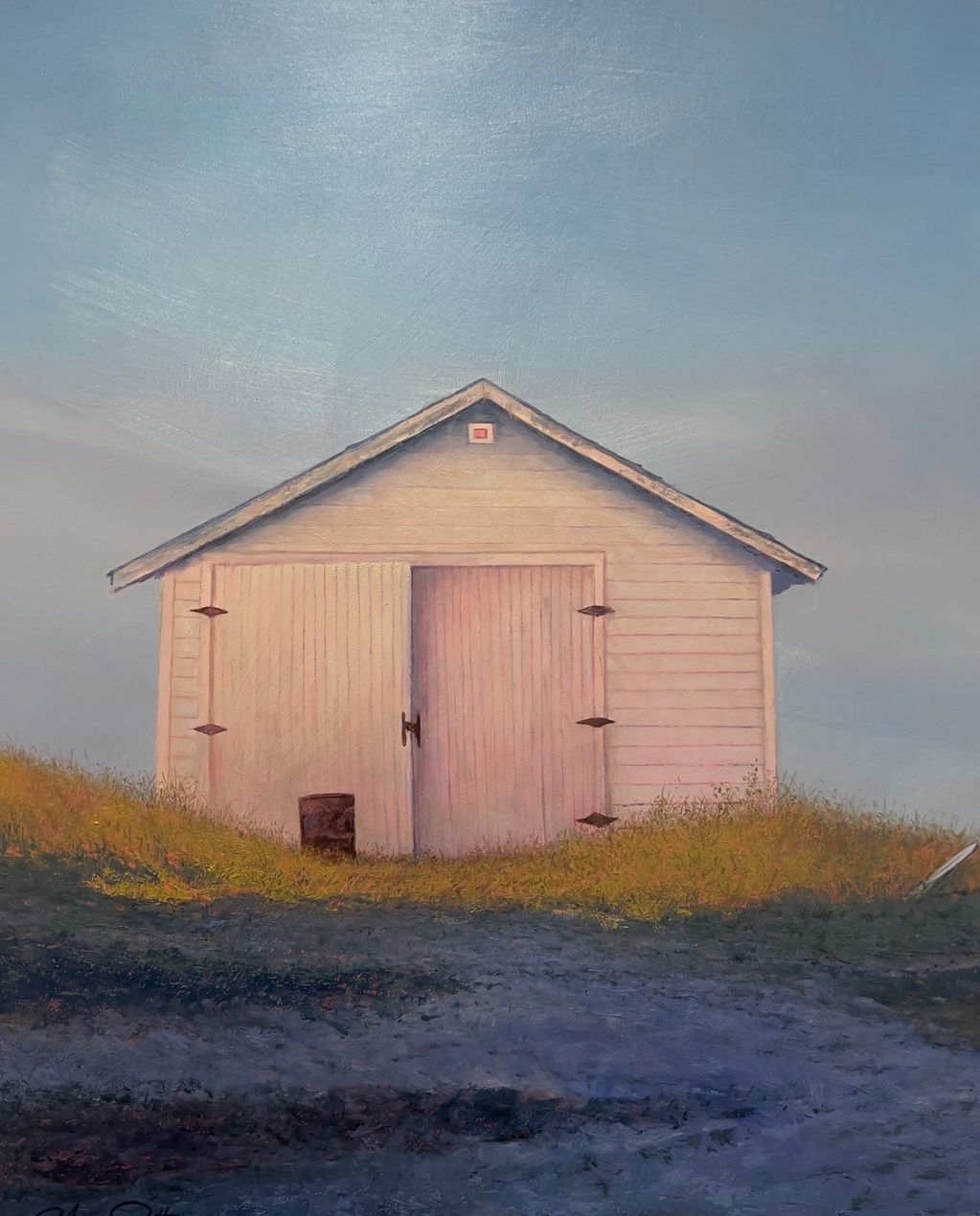 A small white wooden shed on grassy terrain under a clear blue sky.