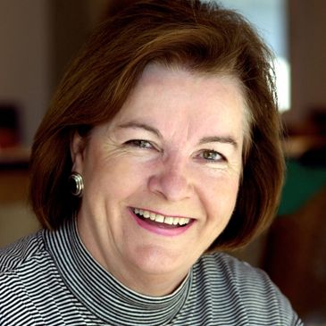 Smiling woman with short brown hair and striped turtleneck.