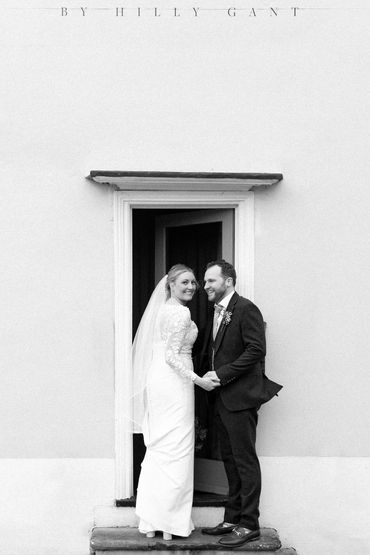 A newly wed couple looking over their shoulders walking into The house by Hilly Gant in Braintree 