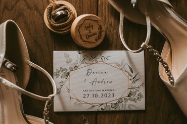 A flat lay image of wedding rings, invite and shoes captured by Kaos Photography Essex