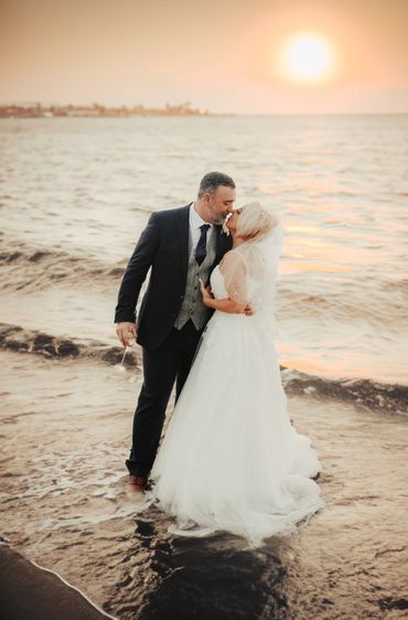 Bride and Groom standing in the sea kissing at Southend on sea. 