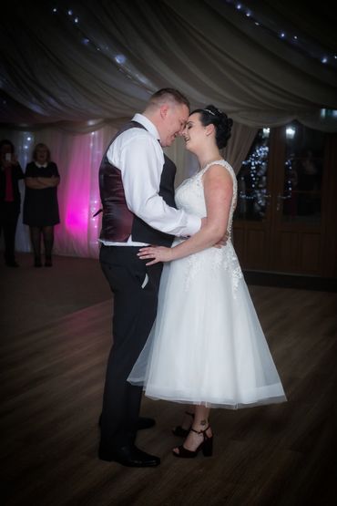 A newly wed couple forehead to forehead sharing their first dance at Newlands Hall 