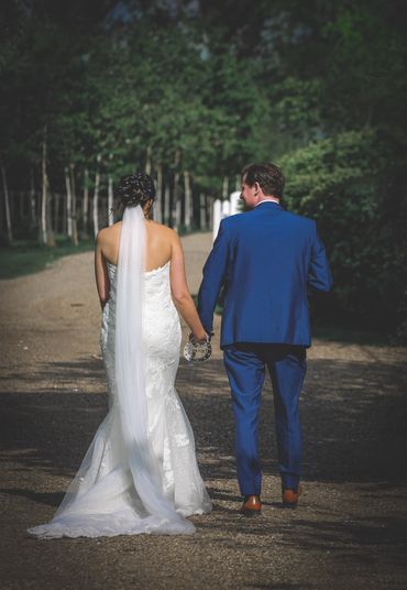 An image of a newly wed couple walking down the path outside of Reid Rooms 