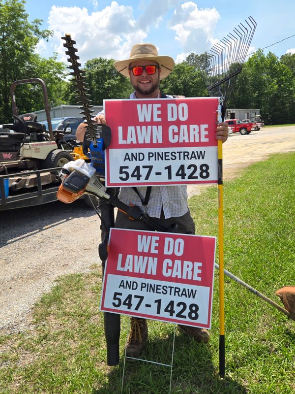 Man holding lawn care signs and tools, advertising services with phone number.