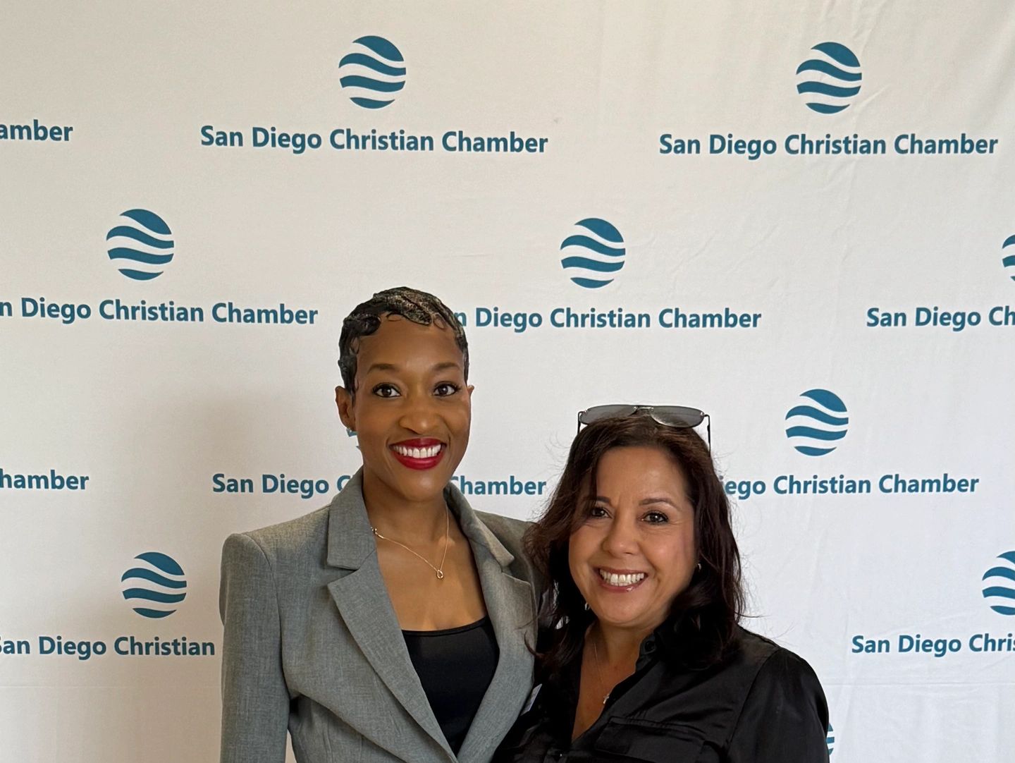 Two women smiling at a San Diego Christian Chamber event.