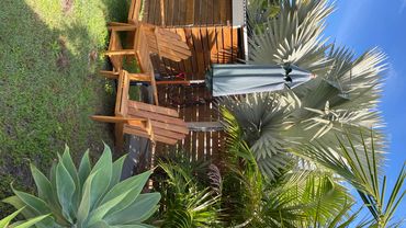 Outdoor seating area with wooden chairs and umbrella.