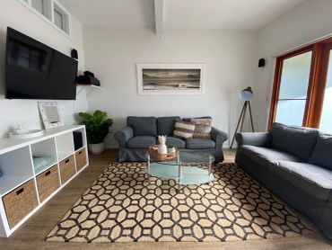 Modern living room with gray sofas and geometric rug.