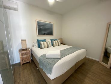 Cozy bedroom with a neatly made bed and bedside tables.