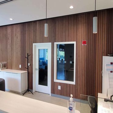 Modern interior with wooden wall panels and glass door.