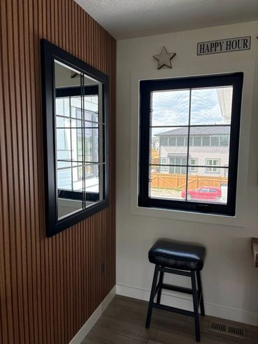 Cozy corner with a stool, window, and mirror.