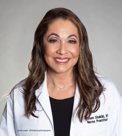 Smiling female nurse practitioner in white coat.
