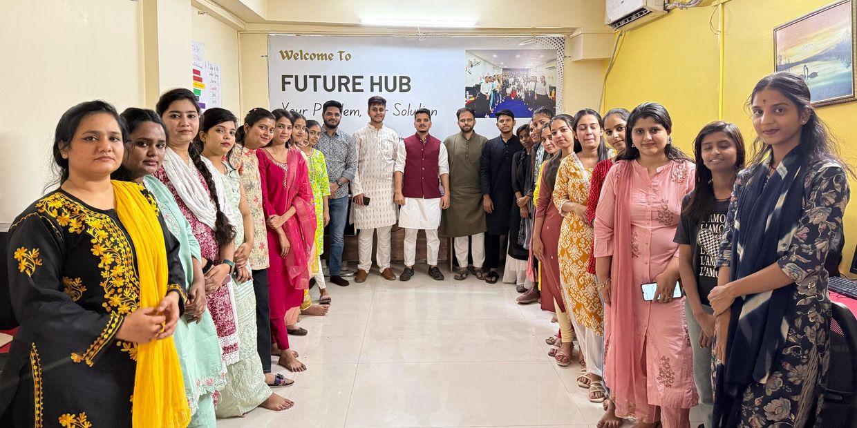 Group photo of diverse young adults standing in two lines inside Future Hub.