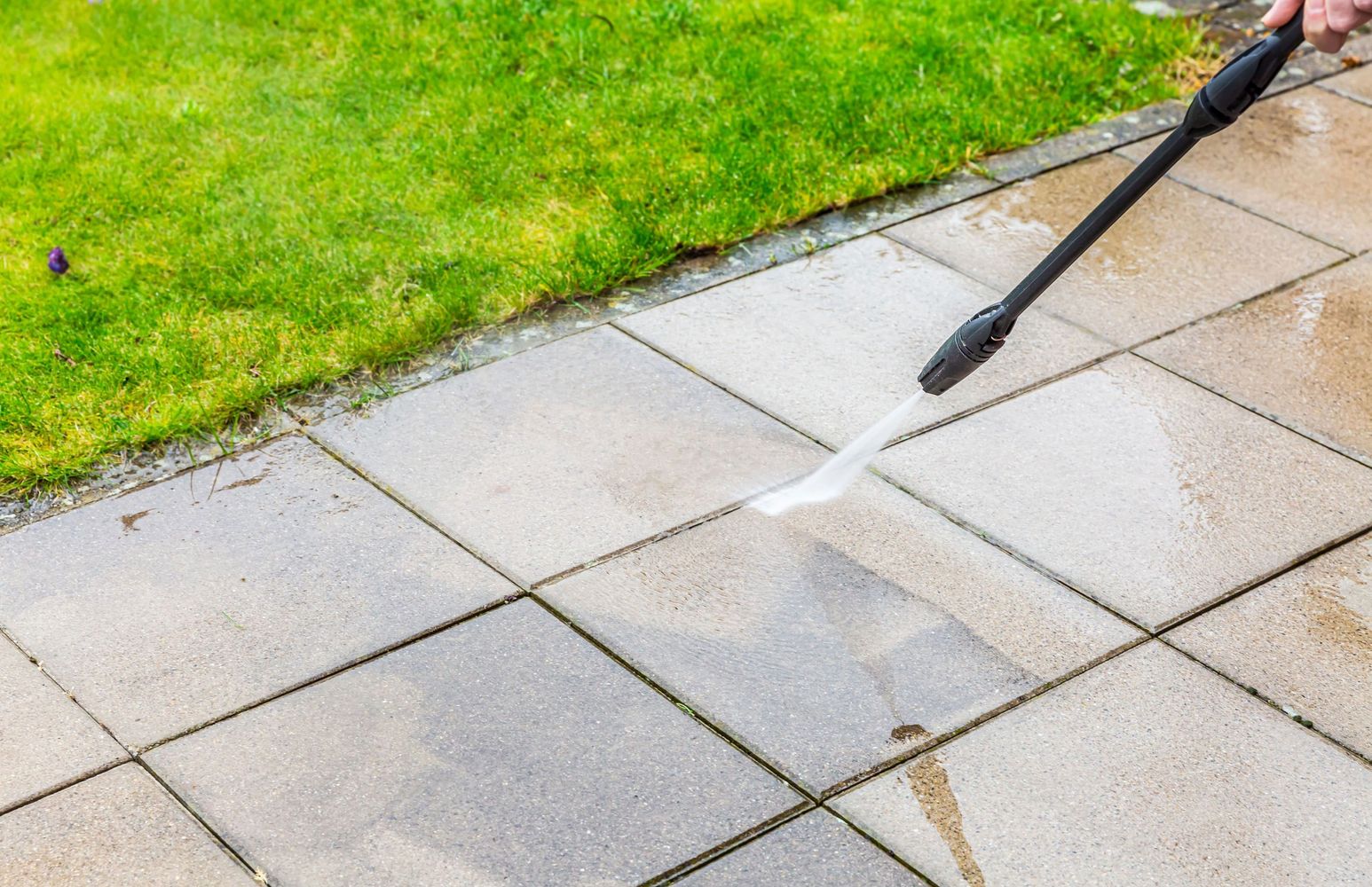 Someone pressure washing a patio