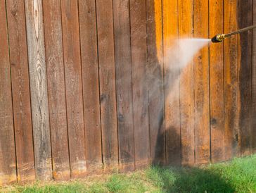 Wood fence being pressure washed