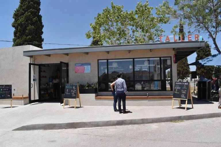 Small modern cafe named Taller with people outside.