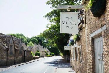 Quiet street beside a village pub on a sunny day.