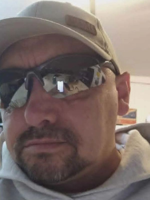 Man wearing sunglasses and beige hat.