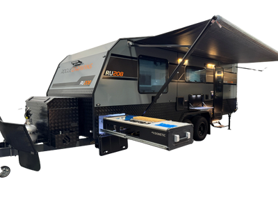 Modern RV camper with extended awning and slide-out kitchen.