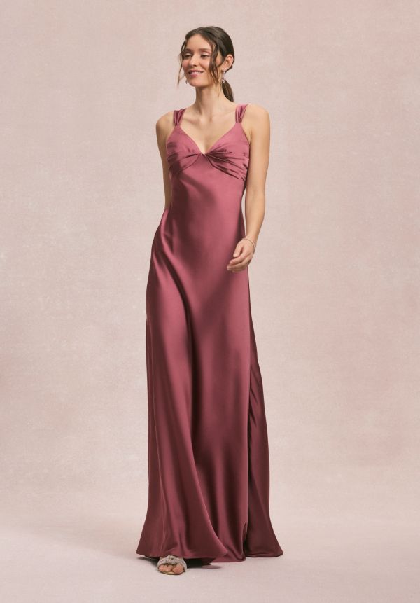 Woman wearing a mauve satin evening gown with twined shoulder straps.