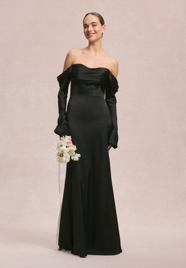 Woman in elegant black off-shoulder gown holding a bouquet.