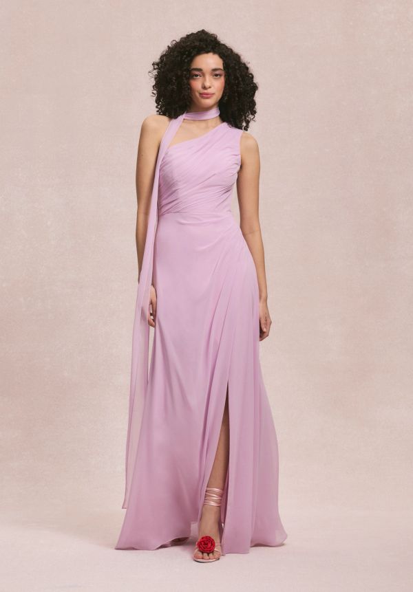 Woman in a long lavender dress with one shoulder design.