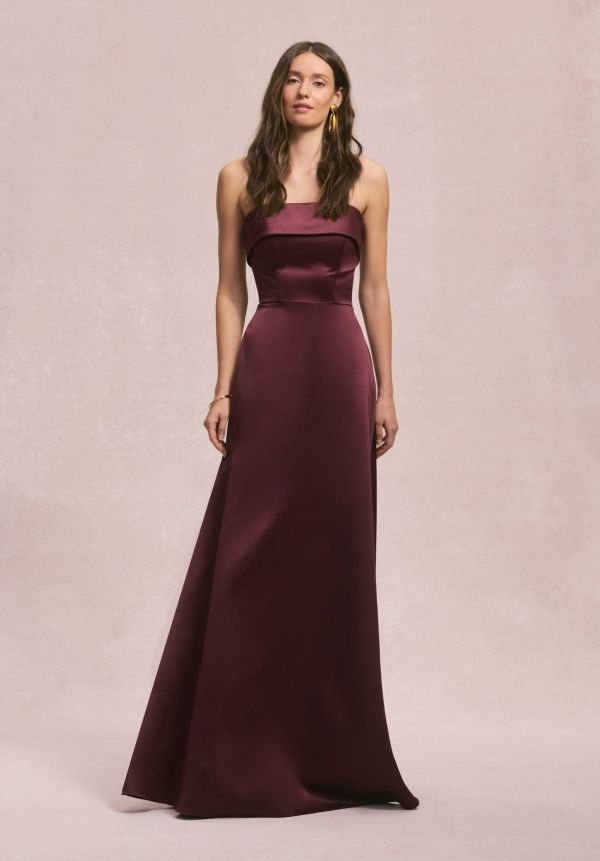 Woman in a sleek, strapless burgundy gown.