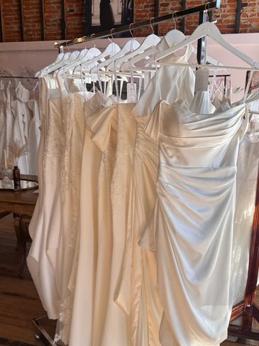 Collection of elegant white wedding dresses hanging on a rack.