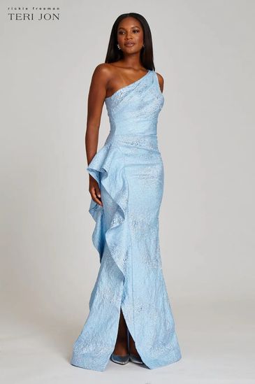 Woman in a one-shoulder light blue gown with ruffles.