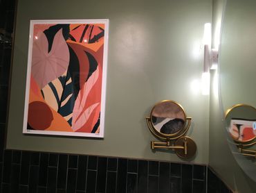 picture and small mirror mounted in bathroom