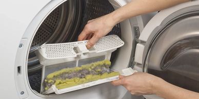 Someone cleaning lint filter of a dryer.