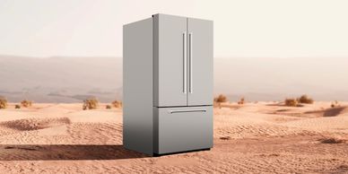 A modern refrigerator in a desert.