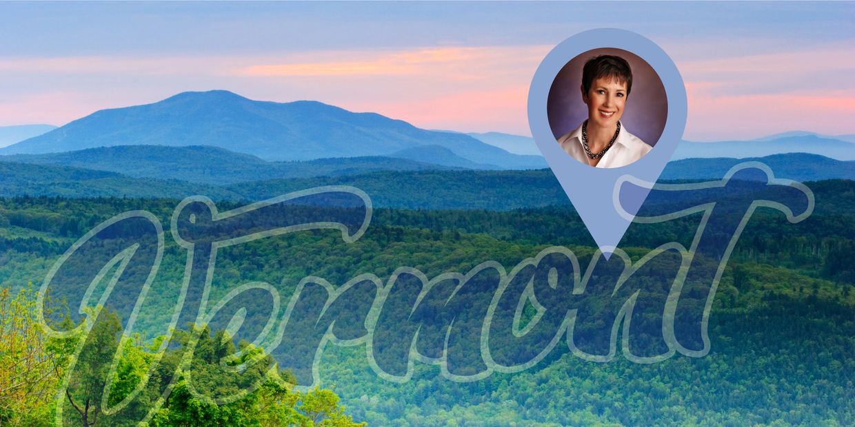 Short-haired, middle-aged woman shown in a map marker above Vermont forests and mountains at sunset.