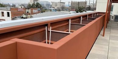 Empty long rectangular planter box on a rooftop patio.