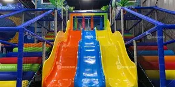 Colorful triple slide in an indoor playground.