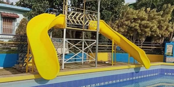 Bright yellow water slides leading into a pool on a sunny day.