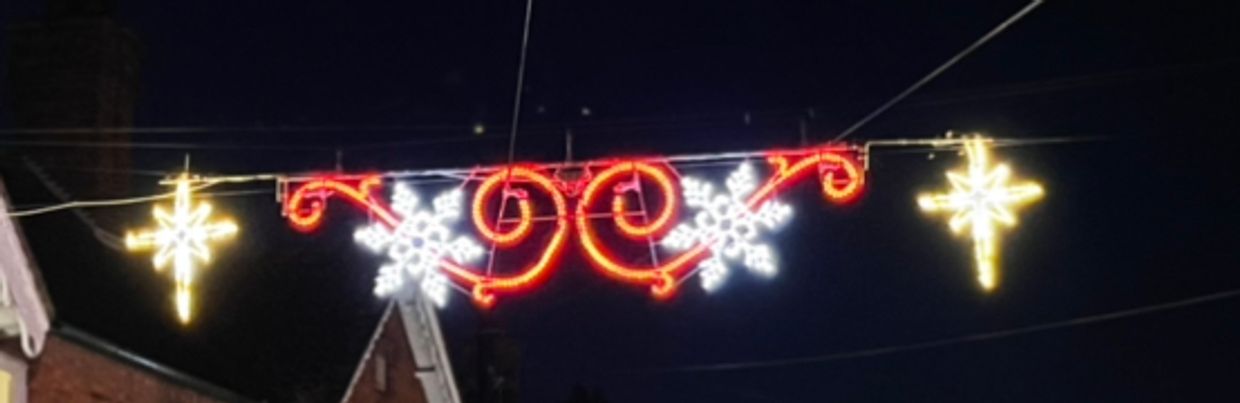 Festive holiday lights with snowflakes and stars at night.