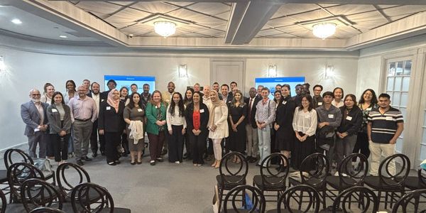 Group photo of diverse professionals in a conference room.