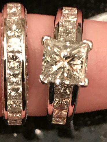 Close-up of two diamond rings with square-cut stones and matching bands.