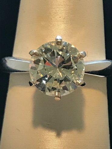 Close-up of a solitaire diamond ring with a six-prong setting.