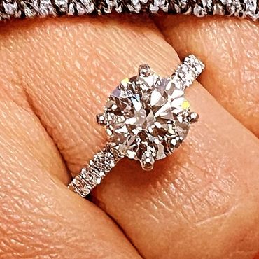 Close-up of a sparkling diamond ring on a finger.
