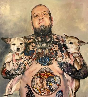 Tattooed man holding two small dogs.