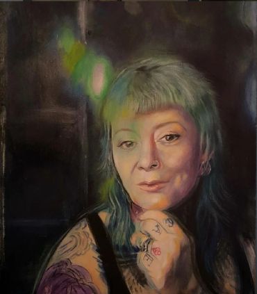Portrait of a tattooed woman with green hair.