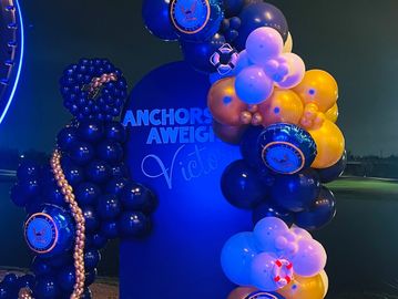 Nautical-themed balloon decoration with a sign saying 'Anchors Aweigh Victoria'.