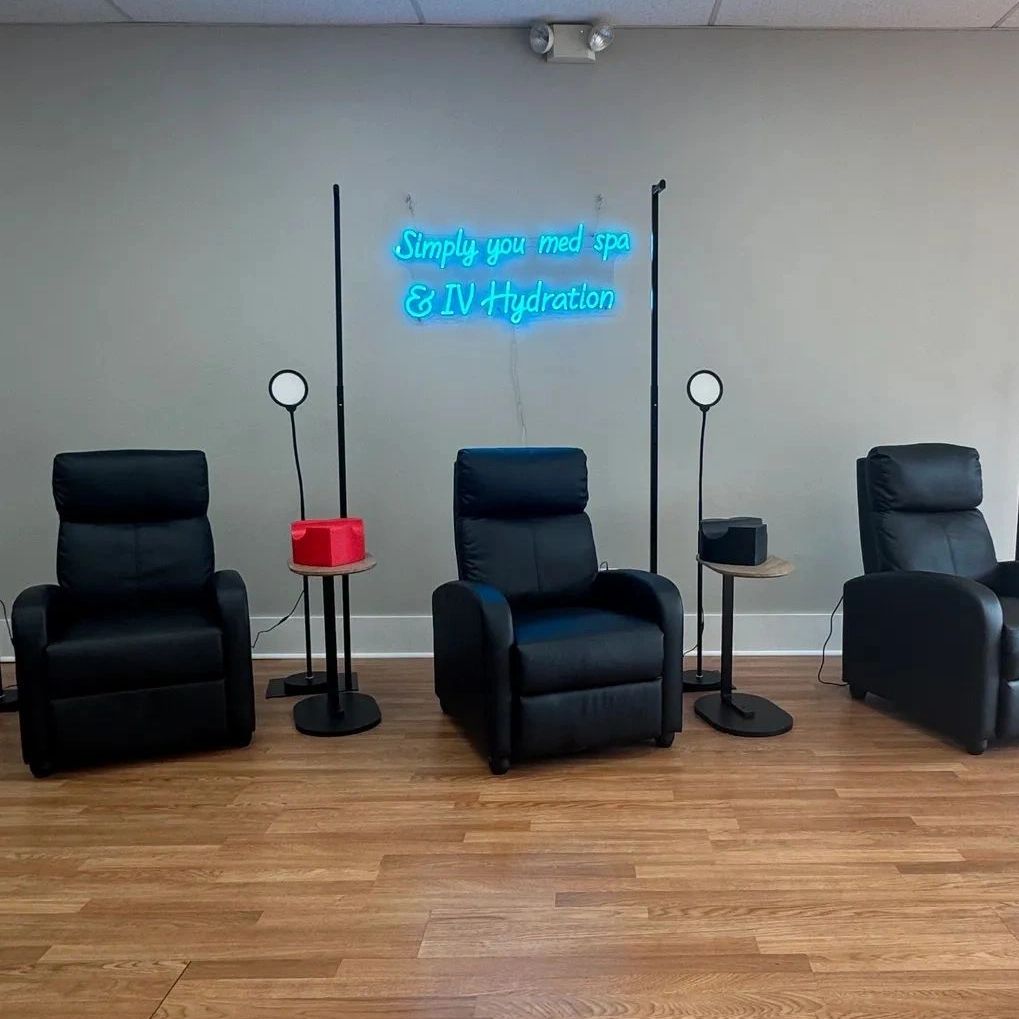 Three black recliners under the neon sign at our Crawfordsville clinic