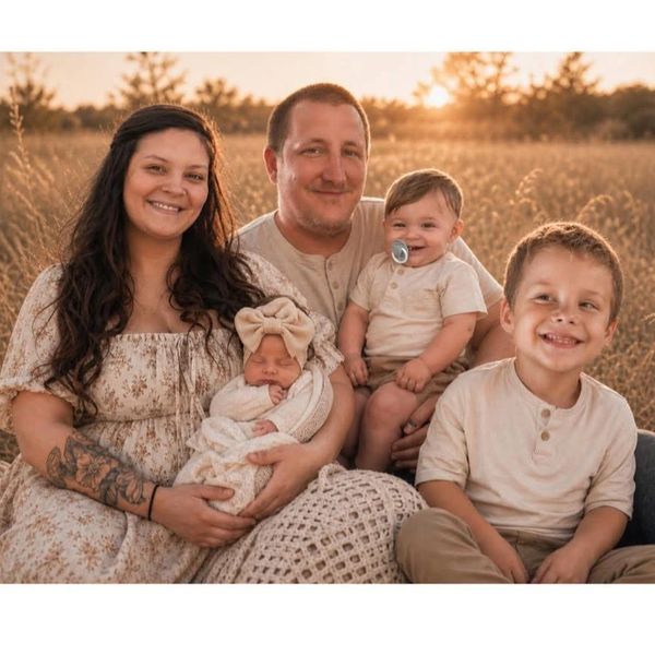 Happy family of five outdoors at sunset.