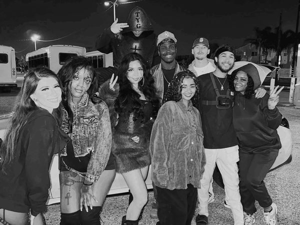 A diverse group of friends posing joyfully outdoors at night.