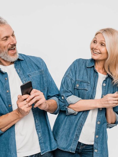 Happy middle-aged couple in denim shirts smiling and interacting.