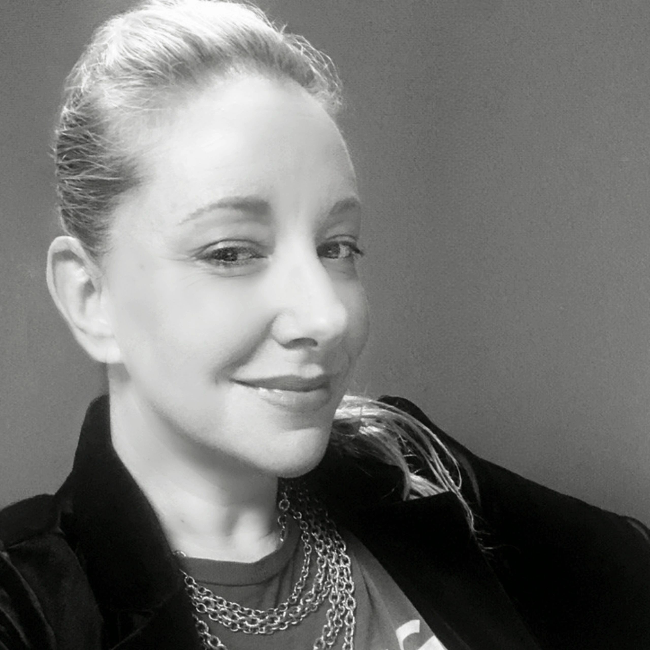 Black and white portrait of a smiling woman.