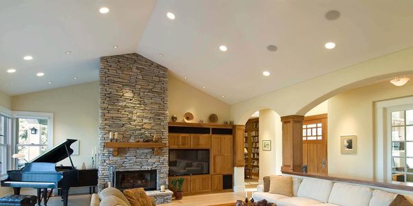 Spacious living room with stone fireplace and grand piano.